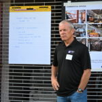 TNS Project Manager Scott Butler pictured in front of a large notepad and mocked up living designs for Adam's Way.