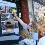 Participant Julia pictured placing a sticky note on preferred Adam's Way mock up designs featuring living room ideas.